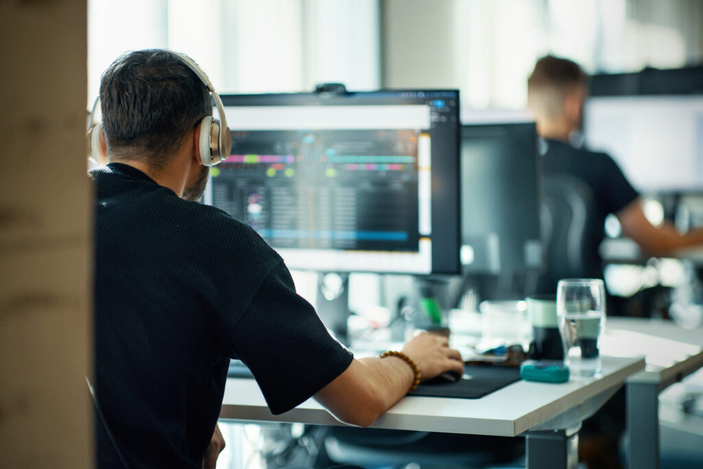 Professionista al lavoro su workstation professionali con monitor avanzato in ambiente ufficio