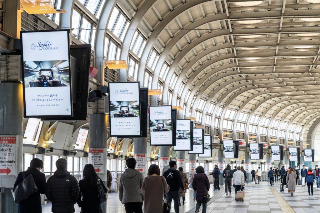 Corridoio di stazione con sistemi di digital signage, totem multimediali e segnaletica digitale per comunicazione informativa e pubblicitaria.