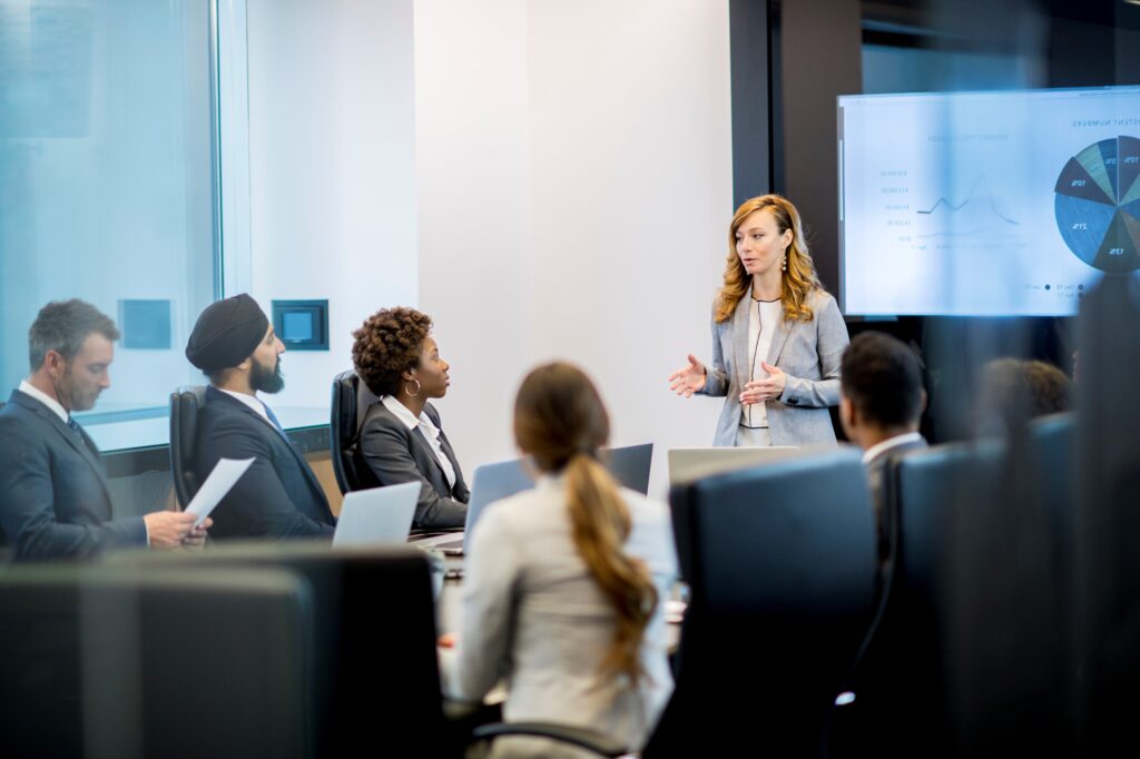 Presentazione in sala riunioni con soluzioni audio video per uffici e display professionale per condivisione dati.