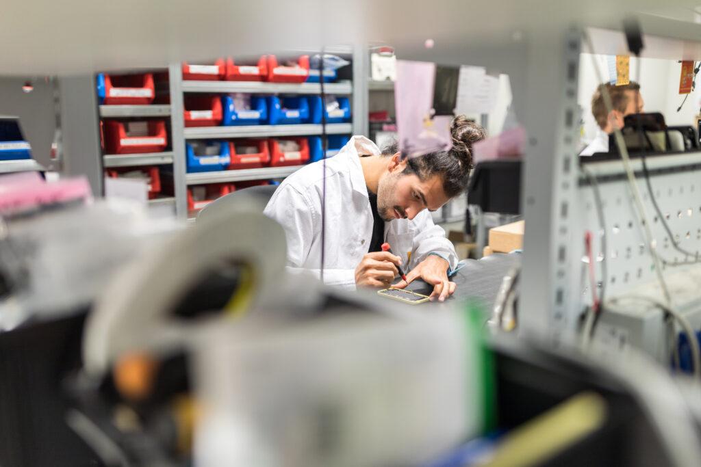 Tecnico al lavoro su assistenza tecnica smartphone per la gestione dei dispositivi mobili come servizio