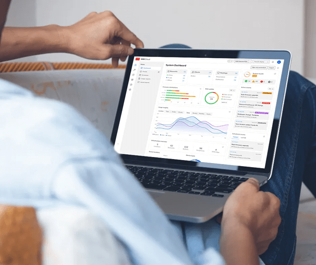 Utente utilizza laptop con dashboard Barco XMS Cloud per monitorare e gestire dispositivi Barco ClickShare in tempo reale