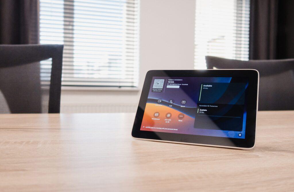 Touch panel su tavolo in sala riunioni con interfaccia Microsoft Teams Room (MTR) per la gestione della videoconferenza.